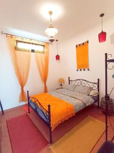 a bedroom with a bed with an orange blanket at Lazy Lizard by the Ocean in Seixal