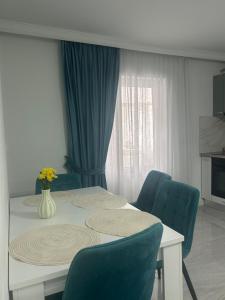 a dining room with a table and blue chairs at Borșa ApartHotel 4 in Borşa
