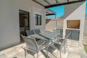 a glass table and chairs on a patio at Casa Tannat by Vindecaf in Cafayate