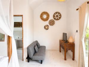 a living room with a couch and a tv at SūKha Amed in Culik
