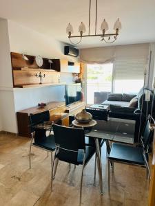 a living room with a dining table and a couch at Apartamento con terraza y piscina en Malgrat de Mar in Malgrat de Mar