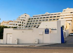 a white building with a hotel in the background at Hotel Atlantida Sol in Figueira da Foz
