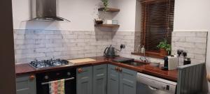 a kitchen with a sink and a stove top oven at The Loft at The Stables in Skibbereen