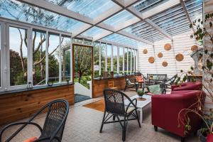 an indoor conservatory with a glass ceiling and chairs at Hotel D'Angleterre in Roscoff
