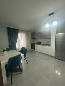a kitchen with a table and chairs and a refrigerator at Borșa ApartHotel 4 in Borşa +13 photos
