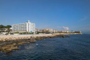 a building on the shore of the water with acean gmaxwell at RVHotels Nieves Mar in L'Escala