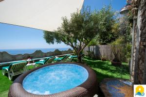 a pool in a yard with chairs and a tree at Casa Francisca in Praiano