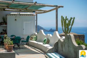 a patio with a couch and a table and chairs at Casa Francisca in Praiano +21 photos