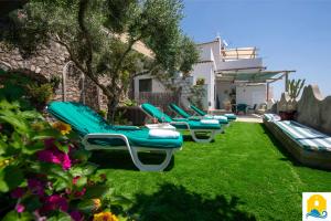 a row of chaise lounge chairs in a yard at Casa Francisca in Praiano