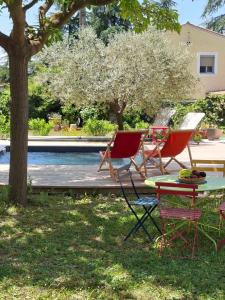 a group of chairs and a table next to a pool at Studio Lumineux avec jardin & piscine à Vaison la Romaine in Vaison-la-Romaine
