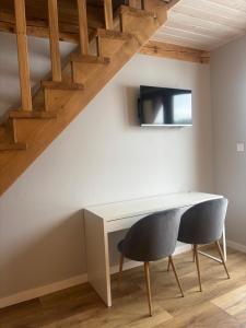 a table and two chairs in a room with stairs at Doboszowka in Lasowka +11 photos