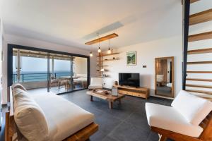 a living room with white furniture and a view of the ocean at L'Astrolabe in Vieux-Fort