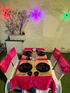 a table with a red table cloth and two chairs at SR Palace - Best Hotel in Vrindavan Near Prem Mandir and Iskcon Temple with Private Parking in Vrindāvan