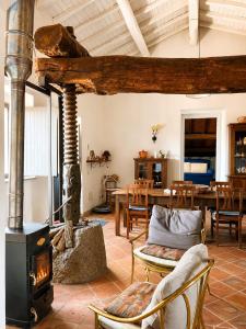 a living room with a wood stove and a table at Etna 1928 Country House in SantʼAlfio
