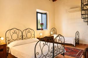 a bedroom with two beds and a window at Etna 1928 Country House in SantʼAlfio