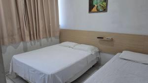 a room with two beds and a window at Shopping 44 Hotel in Goiânia +6 photos