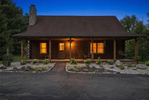 a home with a log cabin with lights on at County Line Cabin in Woodland Beach