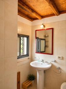 a bathroom with a sink and a mirror at Etna 1928 Country House in SantʼAlfio +32 photos