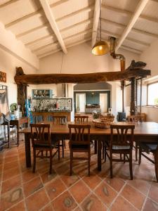 a dining room with a large wooden table and chairs at Etna 1928 Country House in SantʼAlfio