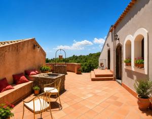 an outdoor patio with two chairs and a table at Etna 1928 Country House in SantʼAlfio