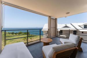 a bedroom with a balcony with a bed and a table at L'Astrolabe in Vieux-Fort