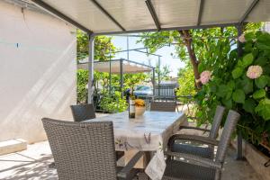 a table and chairs under an umbrella on a patio at House Frane in Supetar