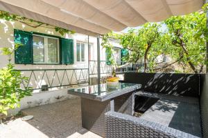 a patio with a glass table and a couch at House Frane in Supetar