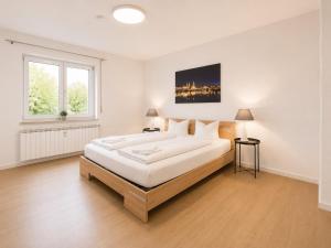 a large white bedroom with a large bed and a window at Dill Apartments Pleinfeld Pacellistraße in Pleinfeld