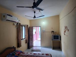 a living room with a ceiling fan and a television at Ballaleshwar cottage in Alibaug