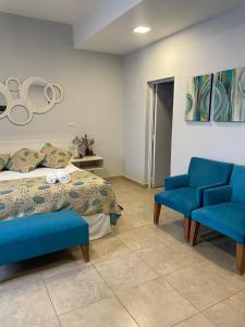 a bedroom with a bed and two blue chairs at Ch Loreto Hotel Boutique in Ciudad de Loreto +50 photos