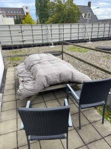a bed sitting on a patio with two chairs at TopSleep Apartments 26-1 in Arnhem