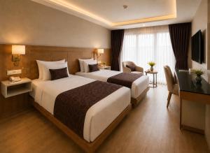 a hotel room with two beds and a television at Anemon Kent Trabzon Otel in Trabzon