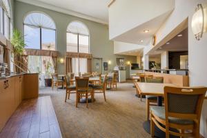 a dining room with tables and chairs and windows at Best Western Davison Inn in Davison
