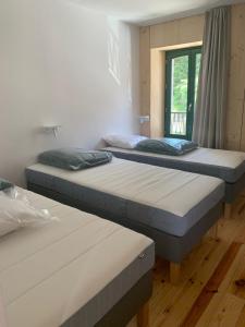 three beds in a room with a window at Logis Hôtel Restaurant Le 1050 in Saint-Agrève +32 photos