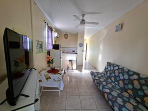 a living room with a couch and a kitchen at Anajodrey in Saint-Joseph
