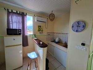 a kitchen with a counter and a clock on the wall at Anajodrey in Saint-Joseph