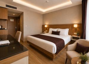 a hotel room with a large bed and a desk at Anemon Kent Trabzon Otel in Trabzon