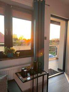 a room with two windows and a table with pots on it at Szum Morza in Wrzosowo