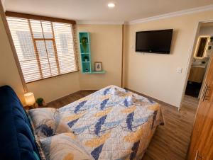 a living room with a couch and a flat screen tv at Hospedaje Edificio Alejandria in Sogamoso