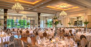 a banquet hall with white tables and chairs and chandeliers at Mullingar Park Hotel in Mullingar