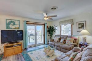 a living room with a couch and a flat screen tv at 4125 - Sea Dawg in Kitty Hawk