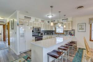 a large kitchen with a large white counter and chairs at 4125 - Sea Dawg in Kitty Hawk +31 photos