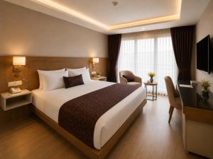 a hotel room with a large bed and a television at Anemon Kent Trabzon Otel in Trabzon