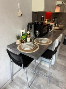 a kitchen with a table with plates and wine glasses at Petit Nid Nature Et Douceurs in Turckheim