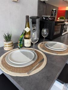 two plates and wine glasses sitting on a kitchen counter at Petit Nid Nature Et Douceurs in Turckheim