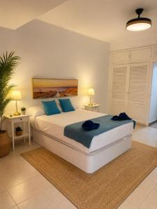 a bedroom with a large bed with blue pillows at Sea View Colony Club in Puerto del Carmen +27 photos
