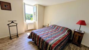 a bedroom with a bed and a lamp and a window at Gîte de roger in Blond