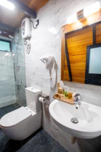 a bathroom with a toilet and a sink and a tv at Sunset Hill Resort in Kandy +51 photos