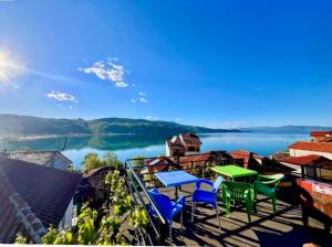 a balcony with tables and chairs overlooking a lake at ERTEO Guest House in Pogradec