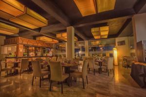 a restaurant with tables and chairs and a bar at Avenra Beach Hikkaduwa in Hikkaduwa